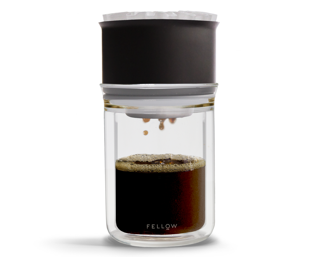Coffee brewing device with glass container and black top on a white background